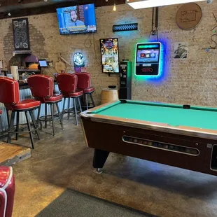 Pool table by front of bar.