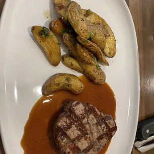 steak, potatoes, and gravy on a white plate