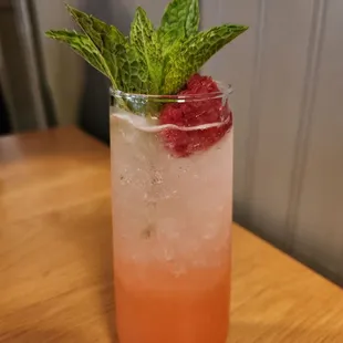 a drink with a raspberry garnish