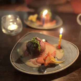 a plate of food with a lit candle