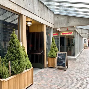 the entrance to a restaurant on a brick sidewalk