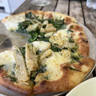 Almond and pesto pizza. With a pepperoni pizza in the background.