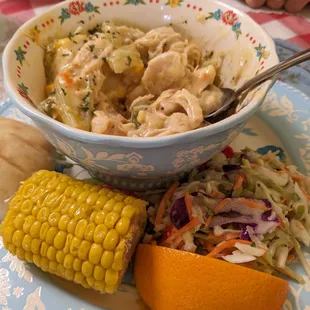 Bowl of Chicken and Dumplings with corn and coleslaw.