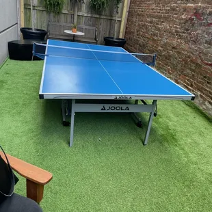 Hidden area of the back patio, featuring a ping pong table in the summertime.