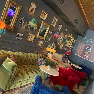 a couch, chairs, tables, and pictures on the wall