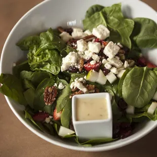 A fan favorite, Mel's Spinach salad boasts creamy feta, bright pear and perfectly sweet candied pecans.