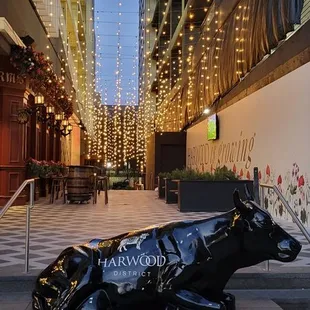 a black cow statue on a city street