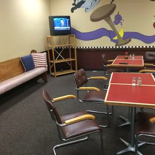 a table and chairs with a television in the background