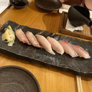 sushi on a black plate on a wooden table