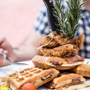 a stack of waffles with a sprig of rosemary on top