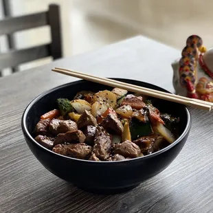 a bowl of food with chopsticks