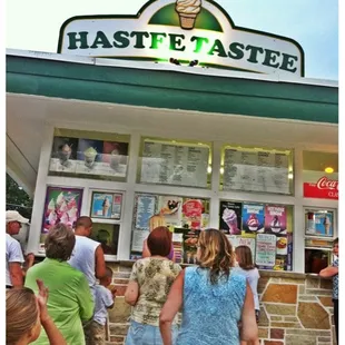  group of people standing in front of a ice cream shop