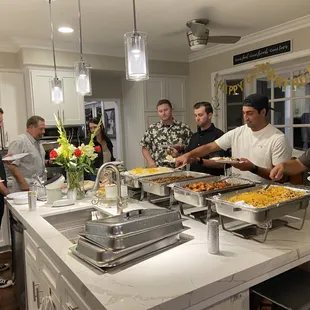 a group of people in a kitchen preparing food