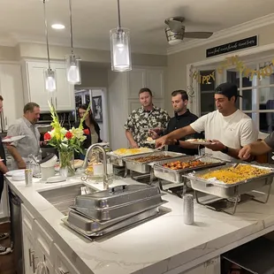 a group of people in a kitchen preparing food