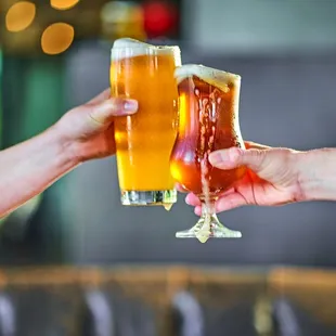 two people clinking glasses of beer