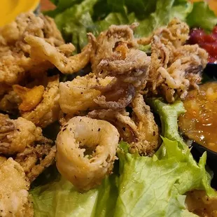 a plate of fried squid and lettuce