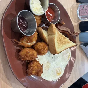 Basic Plate - 3 eggs (over medium) with hash browns, choice of meat (bacon) and bread (brioche).