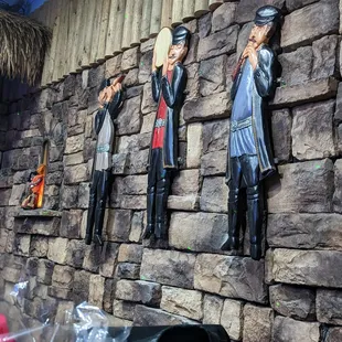 a stone wall with statues of people on it