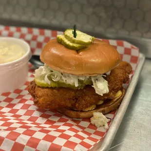 a chicken sandwich with pickles on top