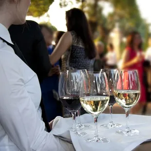 a waiter carrying wine glasses