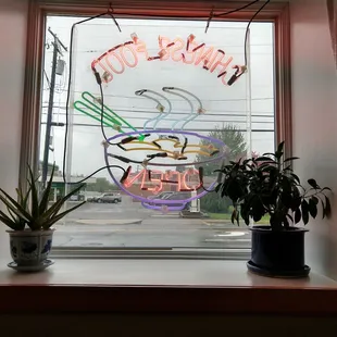 a neon sign in the window of a restaurant