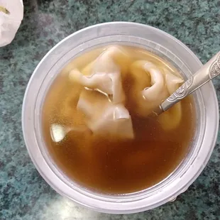 a bowl of soup with dumplings in it