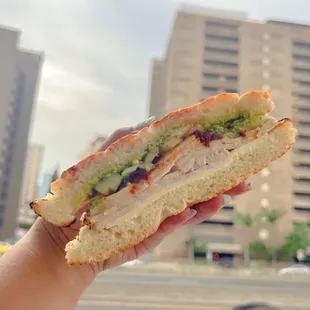 a hand holding a sandwich