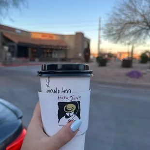 a hand holding a coffee cup