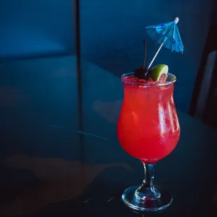a red drink with a blue umbrella