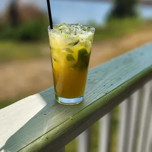 a drink on a deck overlooking a body of water