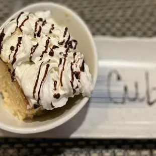 a piece of cake with whipped cream and chocolate drizzle