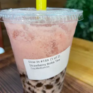 a pink drink in a plastic cup