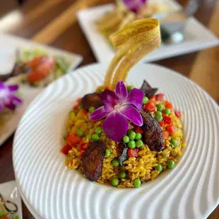 Arroz con Pollo
 
 Traditional cuban chicken with valencia yellow rice garnished with peas, roasted peppers and fried sweet plantains