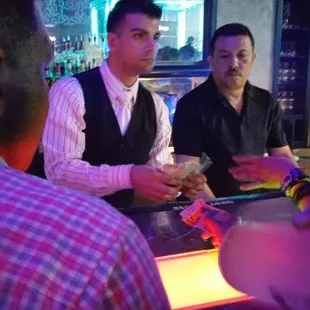 a group of men sitting at a bar