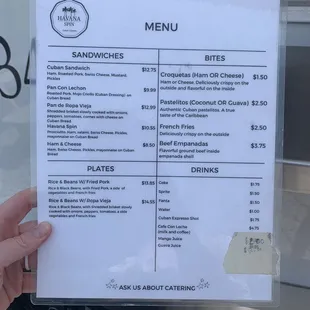 a person holding a menu in front of a food truck