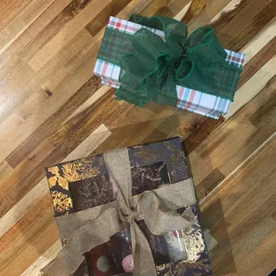 two wrapped presents on a wooden table