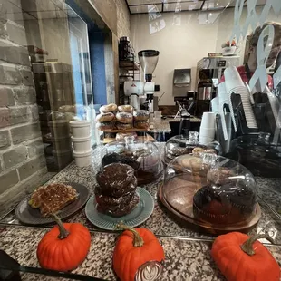 a display of pumpkins and cakes