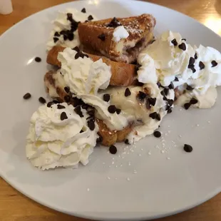 a plate of french toast with whipped cream and chocolate chips