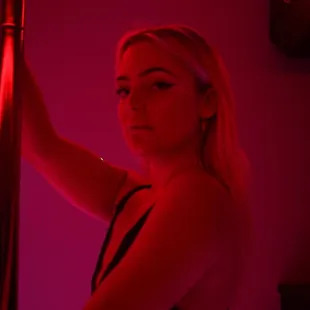 a woman holding a pole in a red light