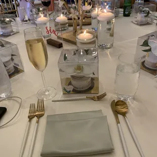 Wedding reception table with elegant gold &amp; white Jacqueline flatware.