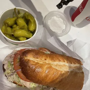 a sandwich, pickles, and a drink