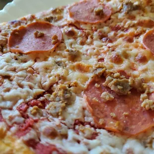 Close-up, Pepperoni and Sausage. (Cut halves of an individual slice, one normal slice is two of these slices combined).