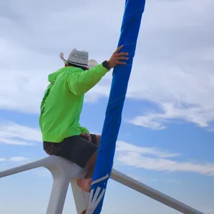 Picture of one of the employees on board sitting at the front of the boat.