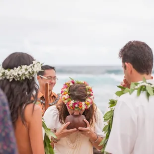 Breathing her &quot;ha&quot;, or breath of life, Kahu Pomaika`i blesses the rings.