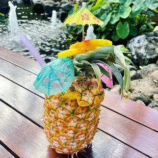a pineapple with a cocktail umbrella