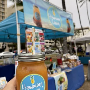a hand holding a jar of juice