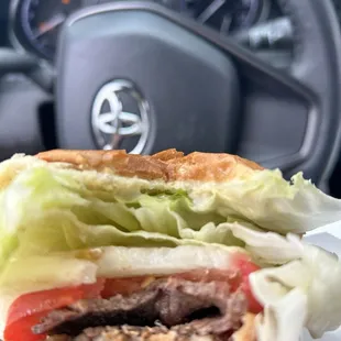 Underneath the giant lettuce, onion, and tomato is a little piece of beef