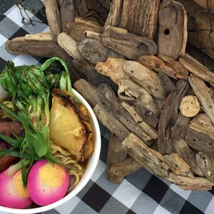a bowl of ramen noodles with a side of radishes