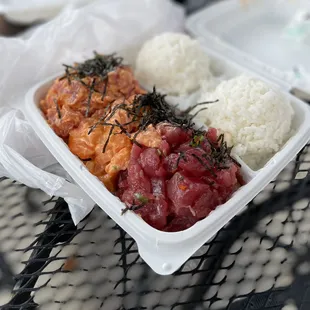 a plastic container with rice, meat, and seaweed