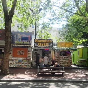a man sitting on a bench in front of a food truck